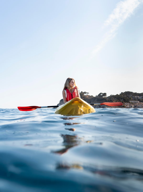 Deportes acuáticos en Cala en Bosc Chica en kayak en medio del mar de Cala en Bosc