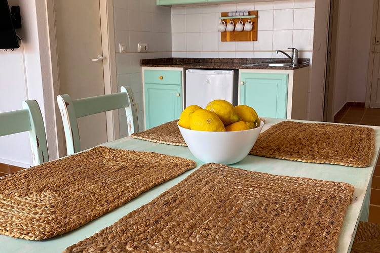 Apartamento 1 dormitorio - 5 Detalle de la mesa del comedor, con manteles individuales de mimbre