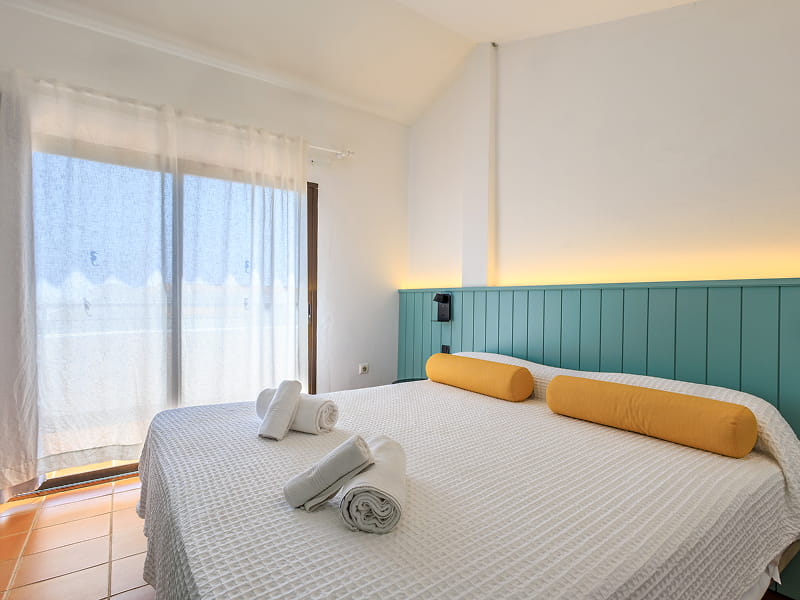 Habitación doble Luminosa habiación con salida directa a la terraza y cabecero de color turquesa
